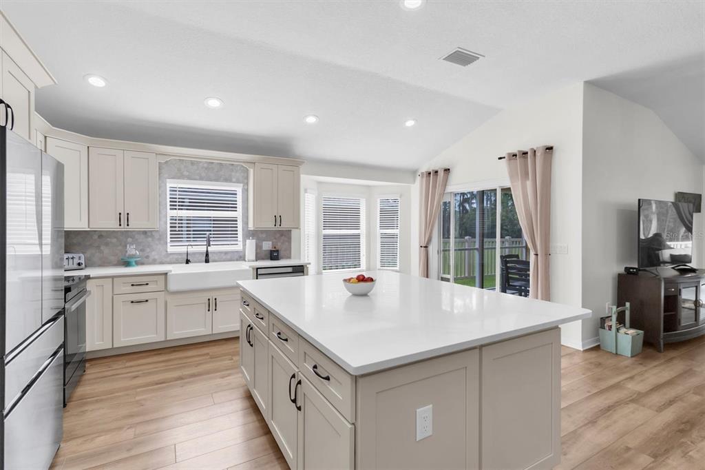 A kitchen with a large white island, light-colored cabinetry, and wood-look flooring — 7832 BLUE SPRING DRIVE, LAND O LAKES, FL