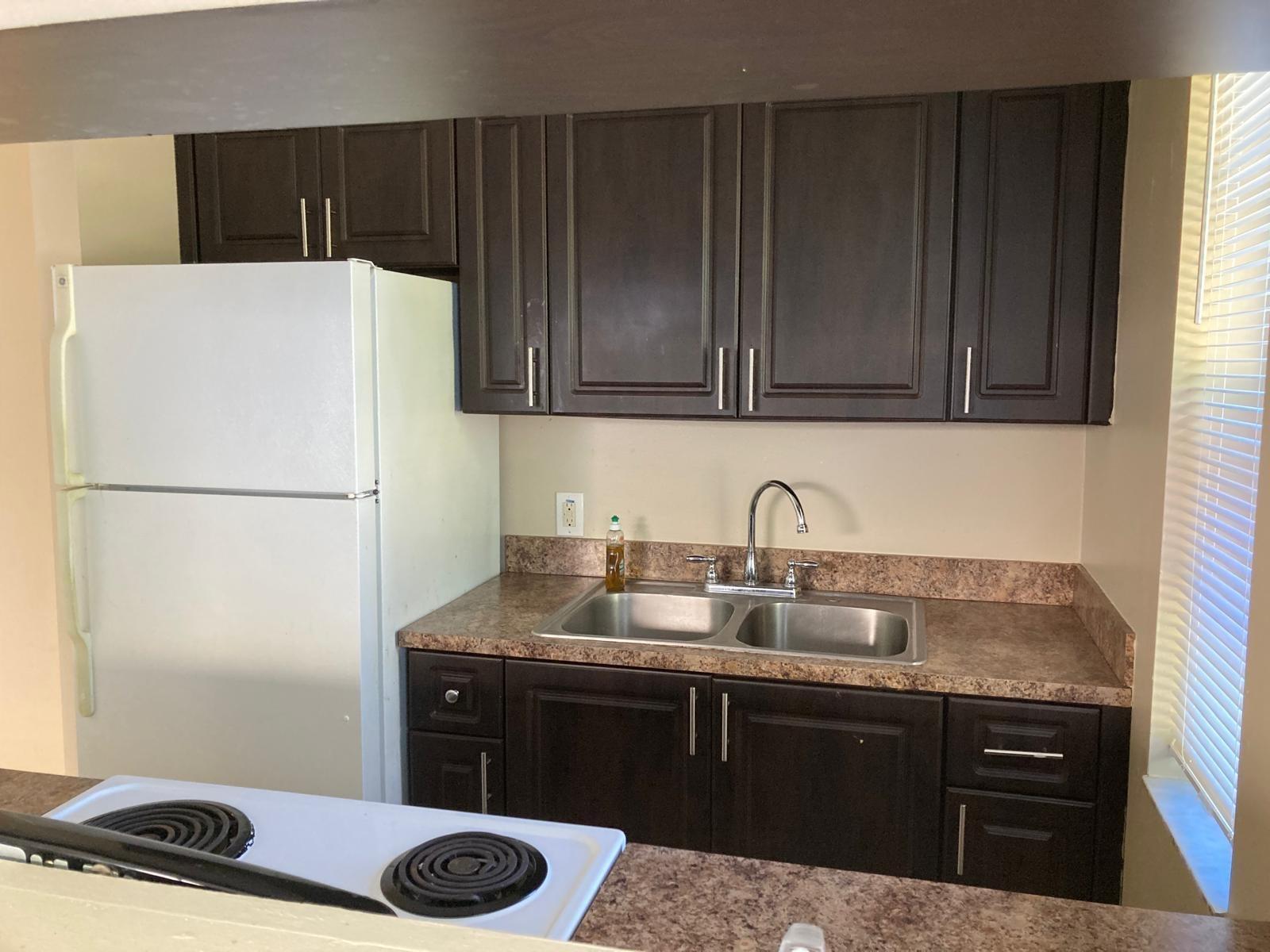 A kitchen features dark wood cabinets, a double-basin sink, and white appliances — 6148 SW 35th Street # 3, Miramar FL 33023, MIRAMAR, FL