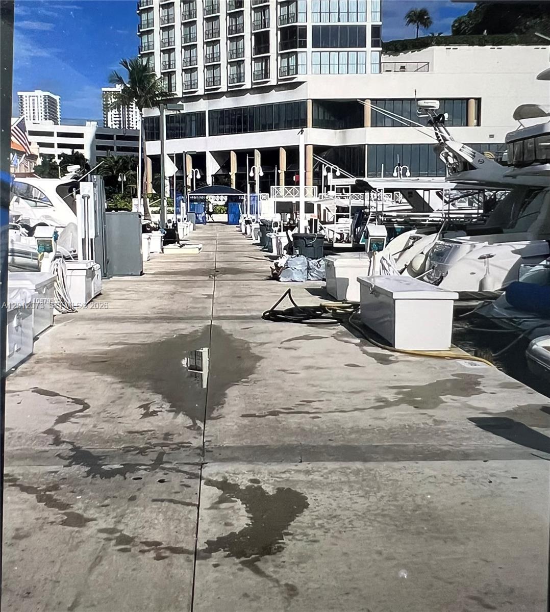 A concrete boat dock with moored yachts and a large building in the background — 1717 N Bayshore Dr # A1448, Miami FL 33132, MIAMI, FL