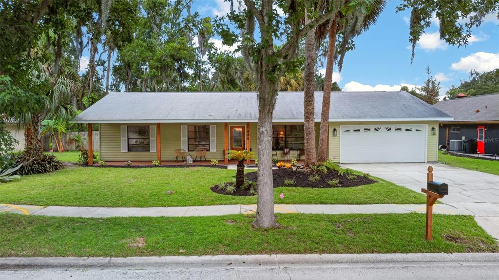 A light green house with a covered porch, wooden posts, and a concrete walkway — 485 MERRIMAC DRIVE, PORT ORANGE, FL