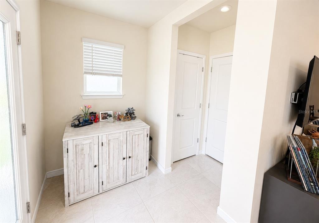 A foyer features a light wood cabinet, tile flooring, and two white interior doors — 1959 SUMMER SERENITY DRIVE, KISSIMMEE, FL