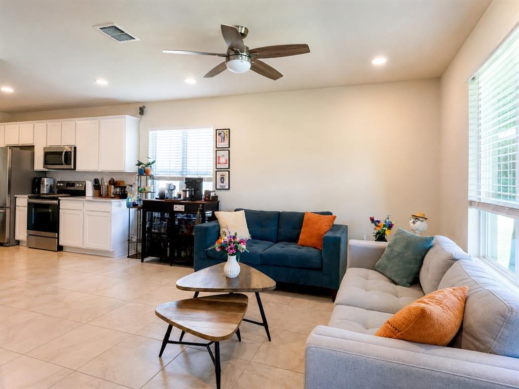 A living room with a blue sofa, light gray sofa, and an open kitchen area — 1959 SUMMER SERENITY DRIVE, KISSIMMEE, FL