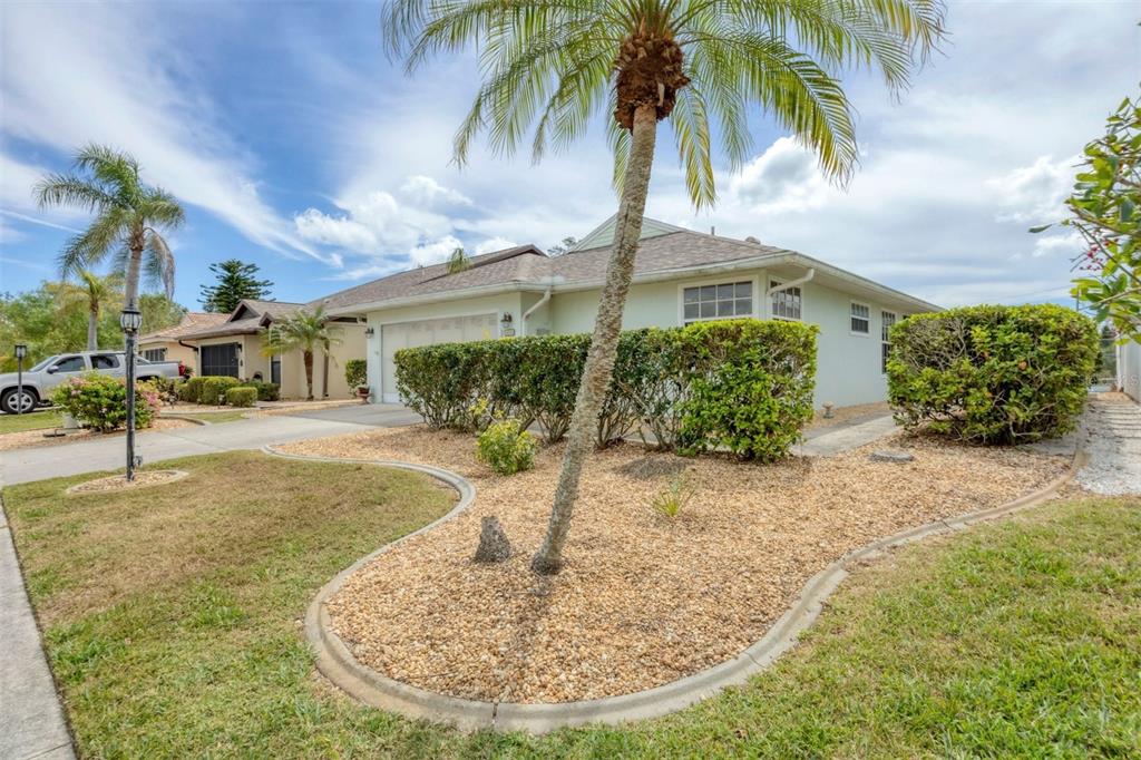 A light green house with a palm tree, gravel landscaping, and a concrete driveway — 14281 PALM TERRACE, PORT CHARLOTTE, FL
