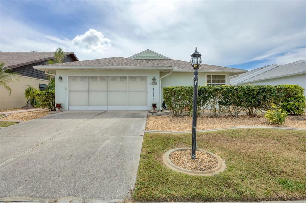 A single-story house with a two-car garage, a concrete driveway, and a front yard lamp — 14281 PALM TERRACE, PORT CHARLOTTE, FL