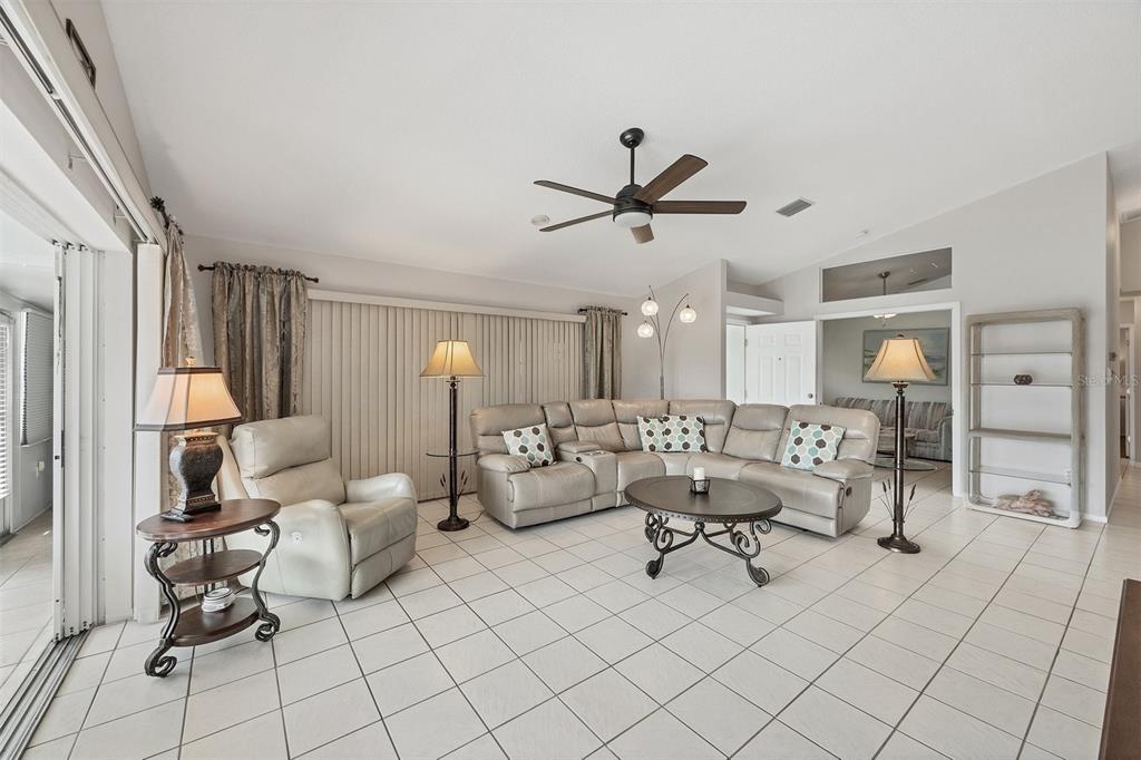 A living room features a beige sectional sofa, a recliner, tile flooring, and a ceiling fan — 14281 PALM TERRACE, PORT CHARLOTTE, FL