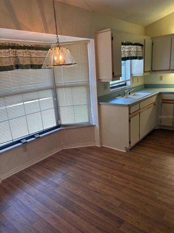 A kitchen with wood-look flooring, white cabinets, green countertops, and a bay window with blinds — 222 MEADOW LAKE DRIVE, EDGEWATER, FL