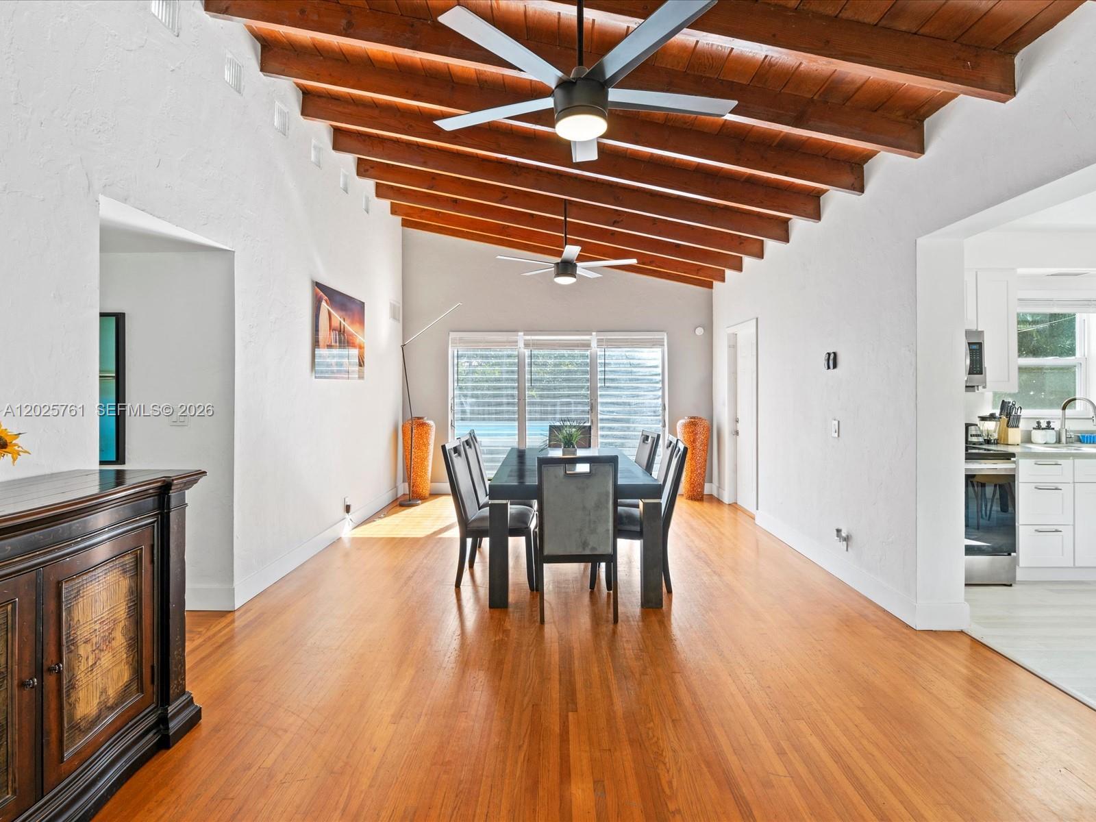 A dining room features a vaulted wood-beamed ceiling, hardwood floors, and a dark dining set — 3981 SW 58th St, Dania Beach FL 33312, DANIA BEACH, FL