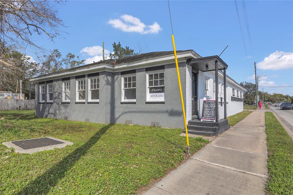 A single-story gray brick commercial building with a sidewalk and a small front entrance porch — 120 S DILLARD STREET, WINTER GARDEN, FL