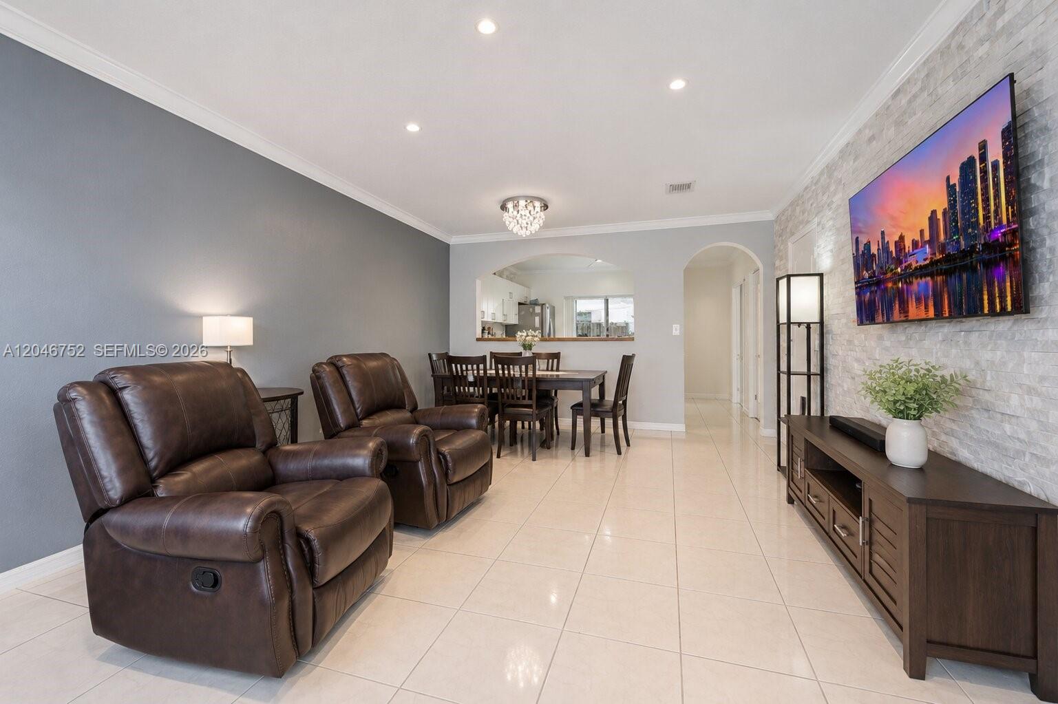 A living room features brown leather recliners, a stone accent wall, and a dining area — 3539 W 76th St # 6, Hialeah FL 33018, HIALEAH, FL