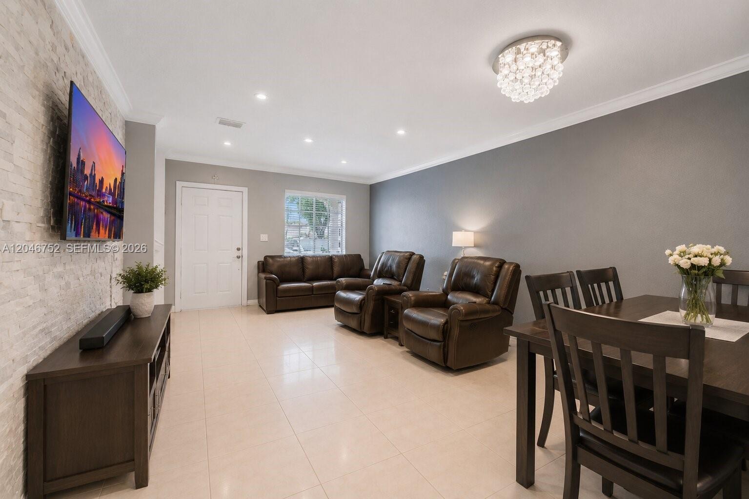 A living and dining area features tile floors, a stone accent wall, and leather furniture — 3539 W 76th St # 6, Hialeah FL 33018, HIALEAH, FL