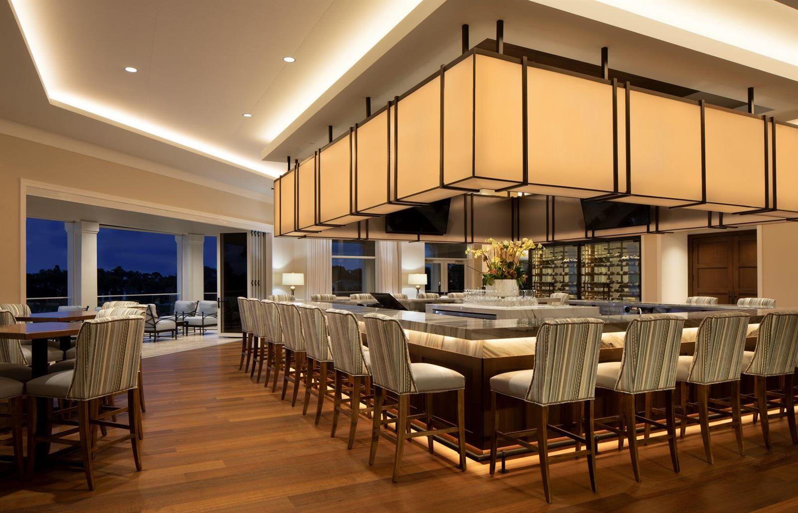 A bar area features a large rectangular light fixture, marble-topped counter, and striped upholstered stools — 111 Caballo Lane, Jupiter FL 33458, JUPITER, FL