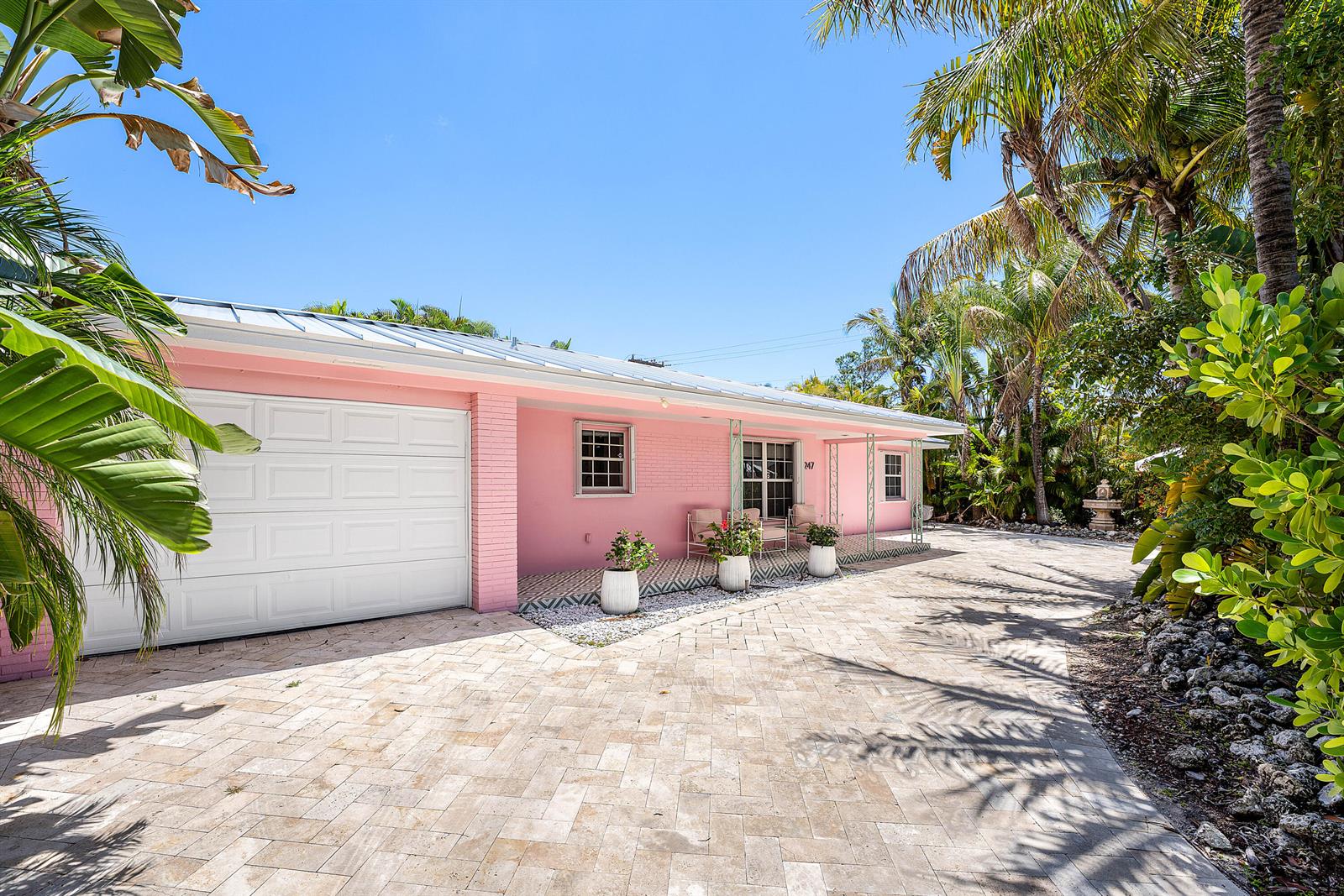A single-story pink house with a white garage door and a paved driveway — 247 SE 3rd Avenue, Delray Beach FL 33483, DELRAY BEACH, FL