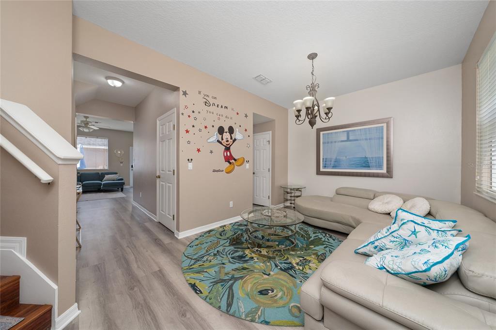 A living room features a sectional sofa, a round patterned rug, and a Mickey Mouse decal — 12744 LANGSTAFF DRIVE, WINDERMERE, FL
