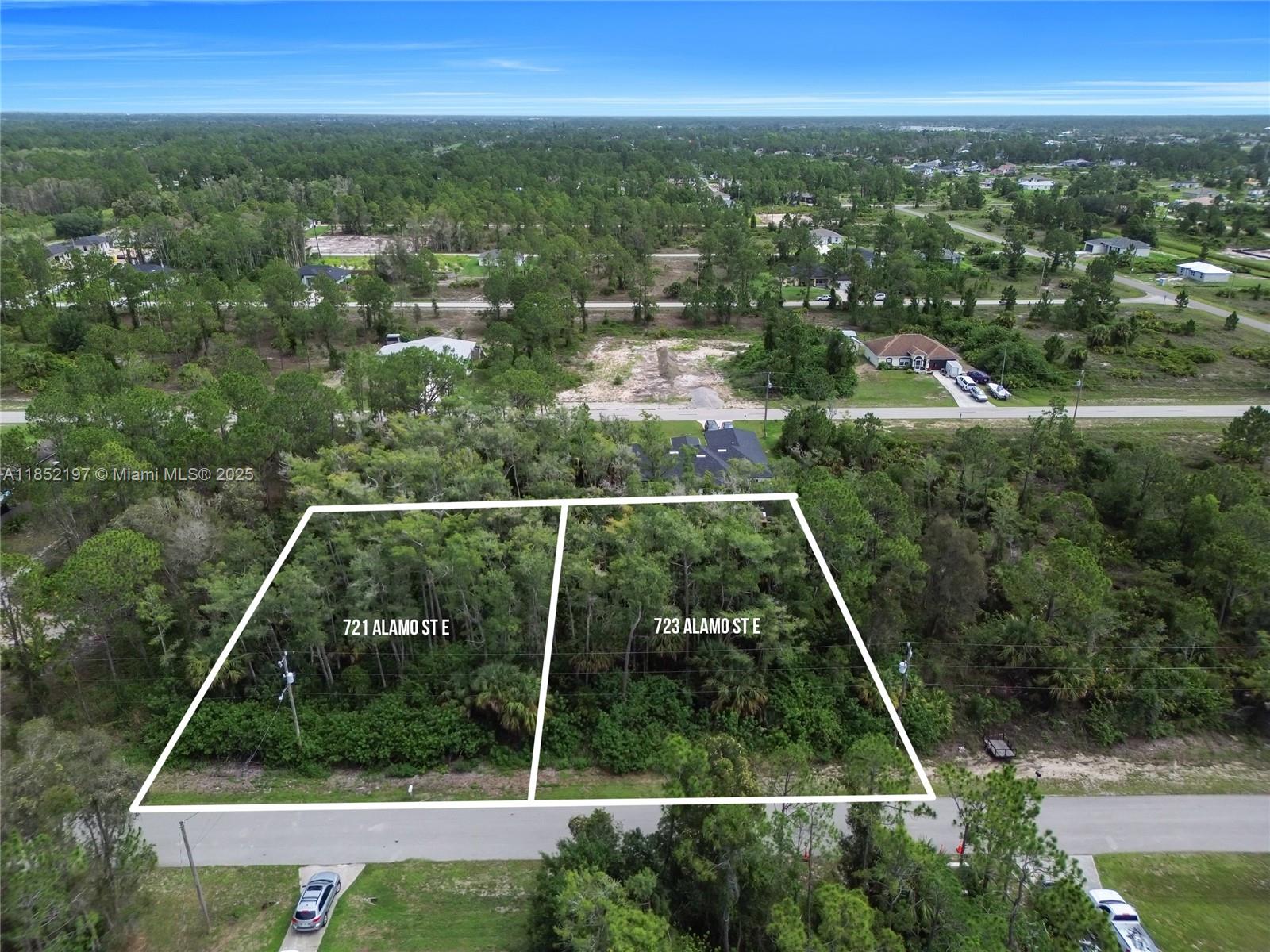 An aerial view shows two adjacent wooded residential lots outlined in white — 723 Alamo ST E, Lehigh Acres FL 33974, LEHIGH ACRES, FL