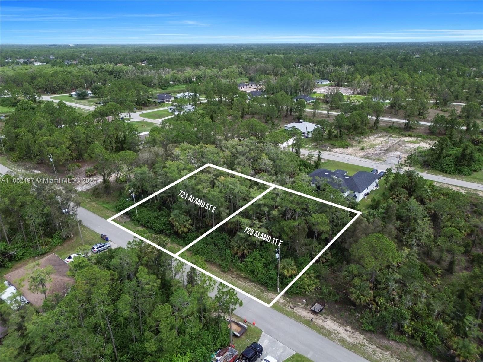 An aerial view shows two adjacent, wooded, undeveloped residential lots outlined in white — 723 Alamo ST E, Lehigh Acres FL 33974, LEHIGH ACRES, FL