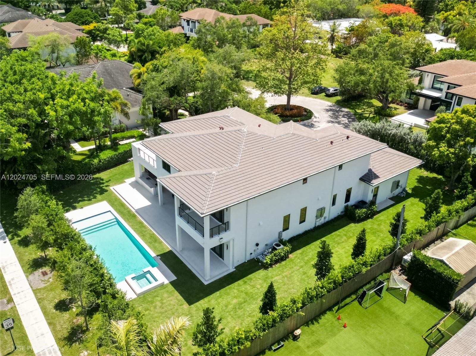 An aerial view shows a two-story white house with a swimming pool and backyard — 9405 SW 72nd Ct, Pinecrest FL 33156, PINECREST, FL