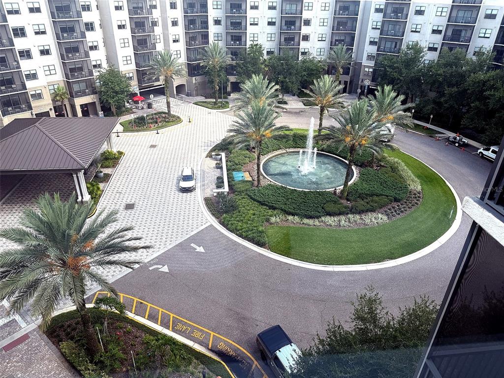 An aerial view shows a circular driveway with a fountain, landscaping, and apartment buildings — 14501 GROVE RESORT AVENUE UNIT 2703, WINTER GARDEN, FL