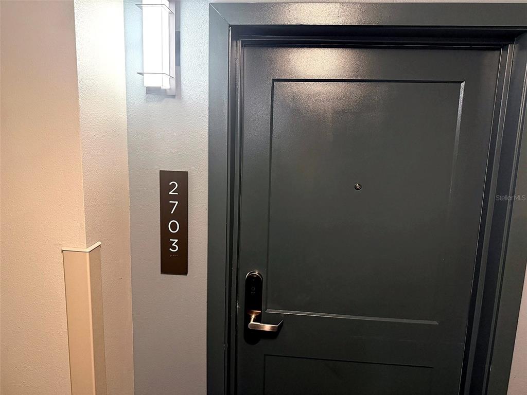 A dark gray door with a modern handle and a vertical unit number sign — 14501 GROVE RESORT AVENUE UNIT 2703, WINTER GARDEN, FL
