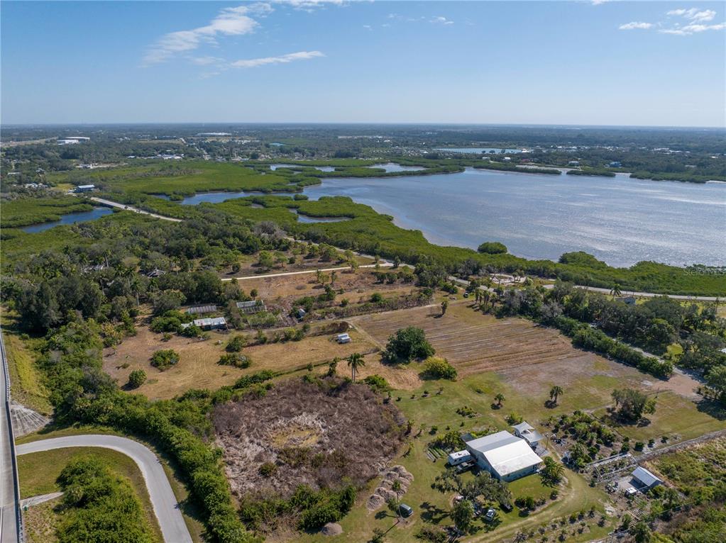 An aerial view shows a rural property with a house, outbuildings, and surrounding coastal vegetation — 282 TERRA CEIA ROAD, PALMETTO, FL