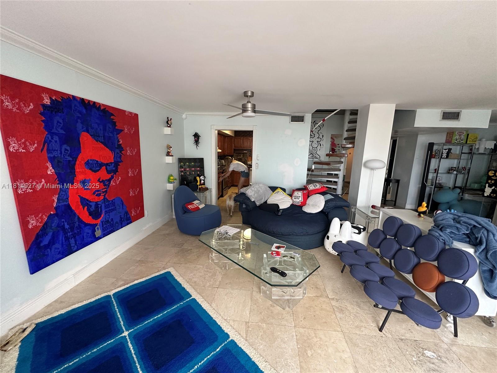 A living room features a large pop-art portrait, a blue circular sofa, and a glass coffee table — 600 NE 36th St, Miami FL 33137, MIAMI, FL