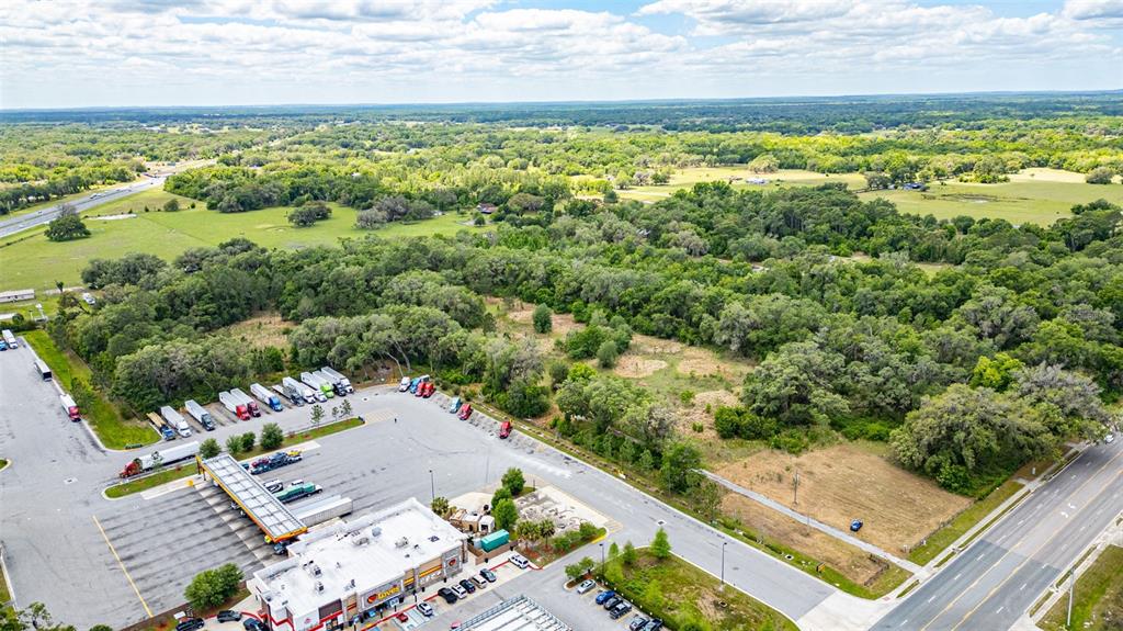 An aerial view shows a Love's travel stop with a parking lot and surrounding wooded land — 2623 W C 48, BUSHNELL, FL