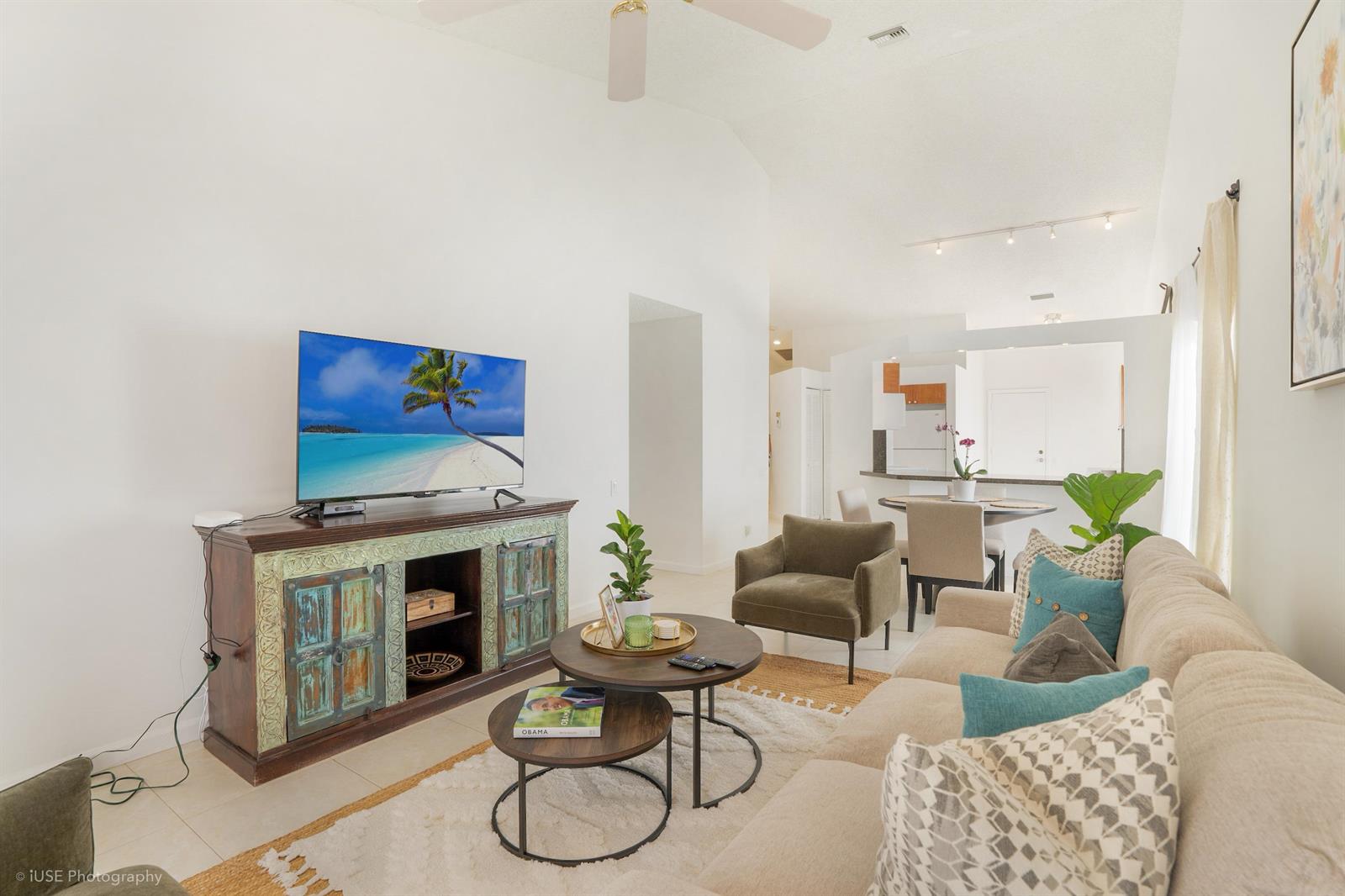 A living room features a television on a rustic cabinet, a sofa, and coffee tables — 21712 Wapford Way, Boca Raton FL 33486, BOCA RATON, FL