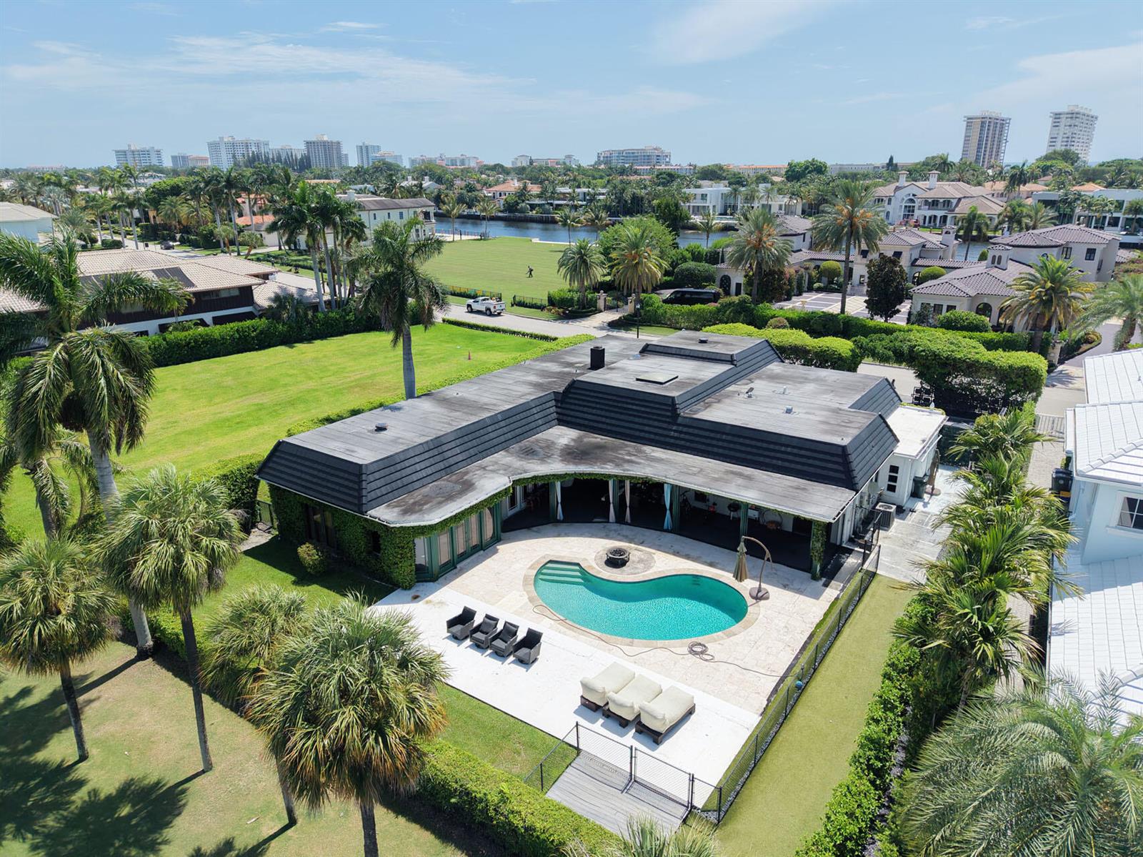 An aerial view of a house with a dark roof, pool, and patio in Florida — 1877 Royal Palm Way, Boca Raton FL 33432, BOCA RATON, FL