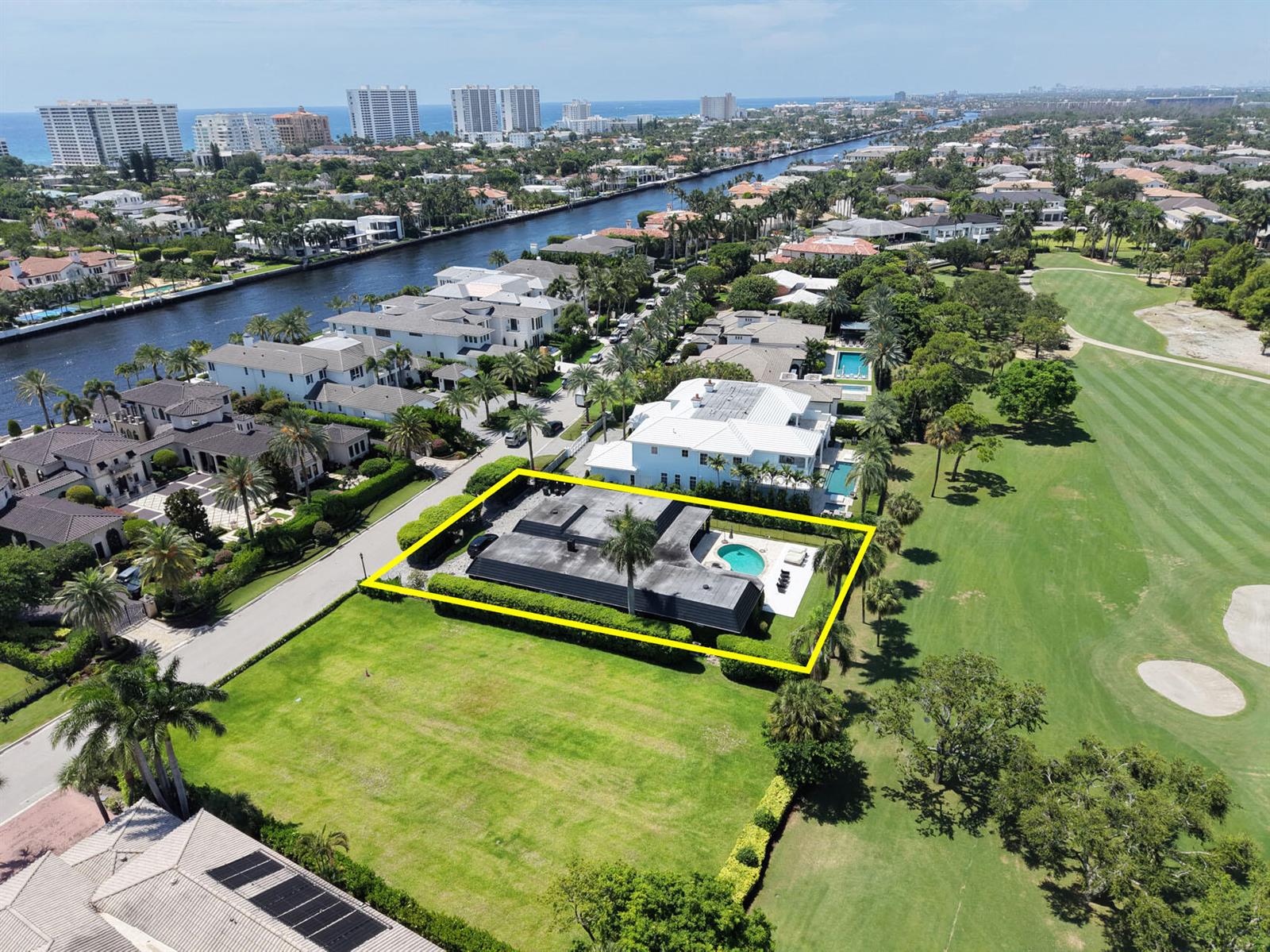 An aerial view shows a flat-roofed house with a pool, surrounded by a large lawn — 1877 Royal Palm Way, Boca Raton FL 33432, BOCA RATON, FL