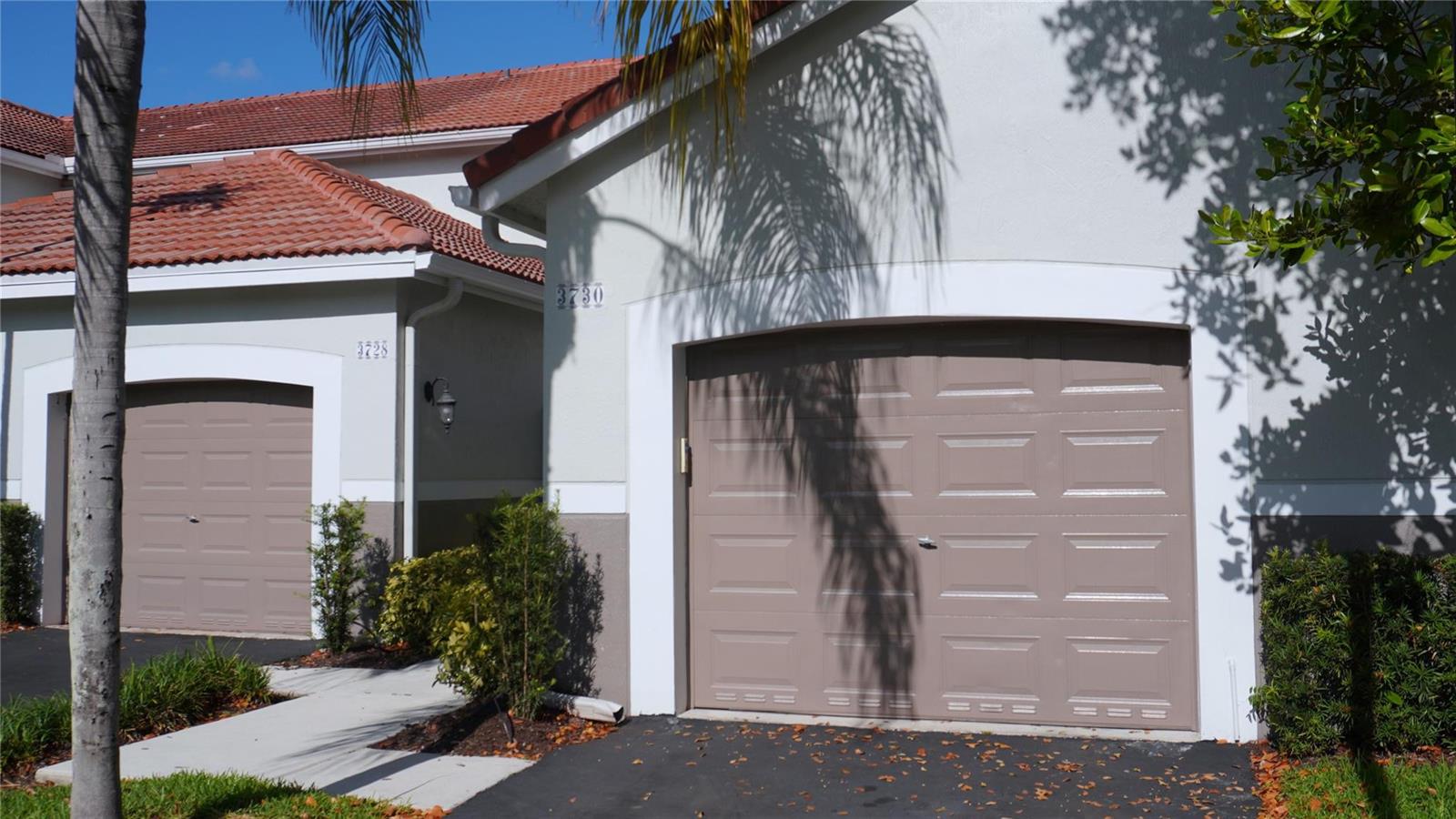 A view of two adjacent garage doors with tan panels and white trim on a house — 3730 San Simeon Circle, Weston FL 33331, WESTON, FL