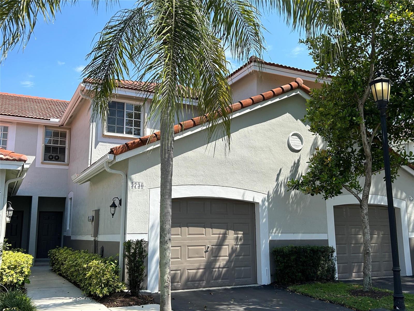 A two-story townhouse exterior features a beige stucco facade, a tile roof, and a garage — 3730 San Simeon Circle, Weston FL 33331, WESTON, FL
