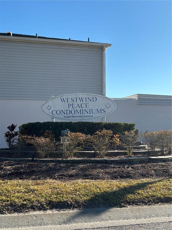 A sign for Westwind Place Condominiums stands in front of a building with light-colored siding — 11804 CYPRESS HILL CIRCLE UNIT 45, TAMPA, FL