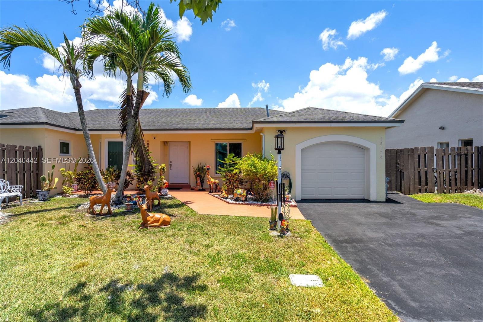 A single-story house with a garage, palm trees, and lawn ornaments in the front yard — 10170 NW 54th Ter, Doral FL 33178, DORAL, FL