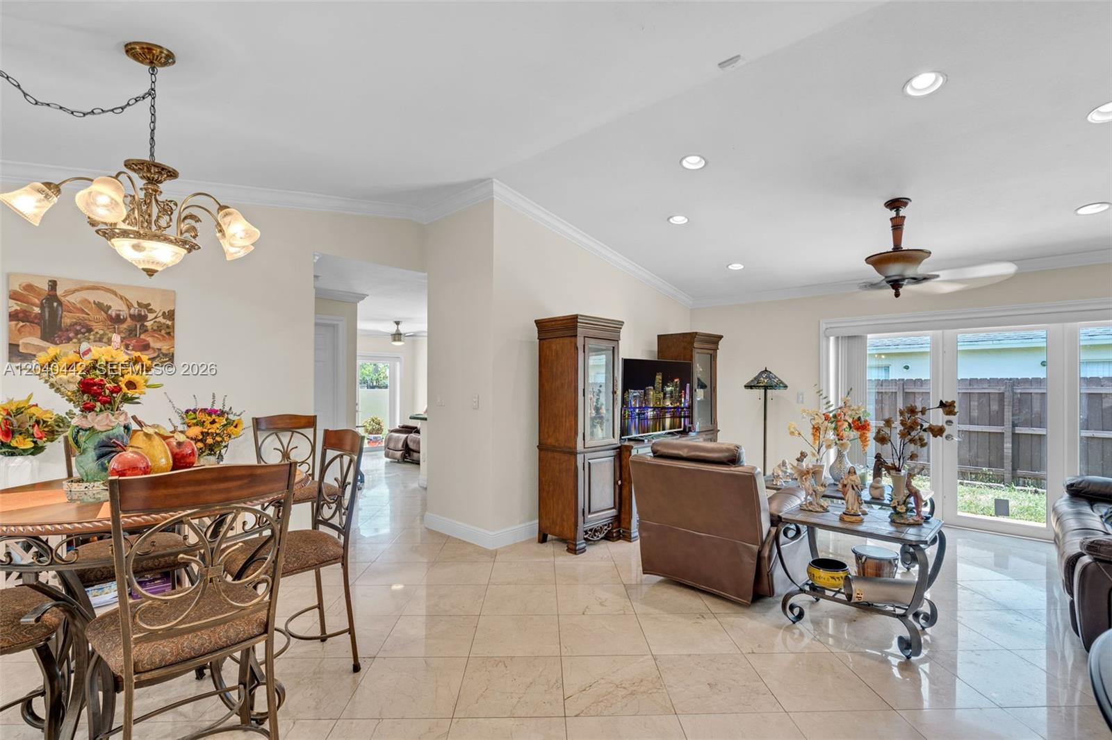 A dining area and living room feature tile floors, recessed lighting, and a glass sliding door — 10170 NW 54th Ter, Doral FL 33178, DORAL, FL