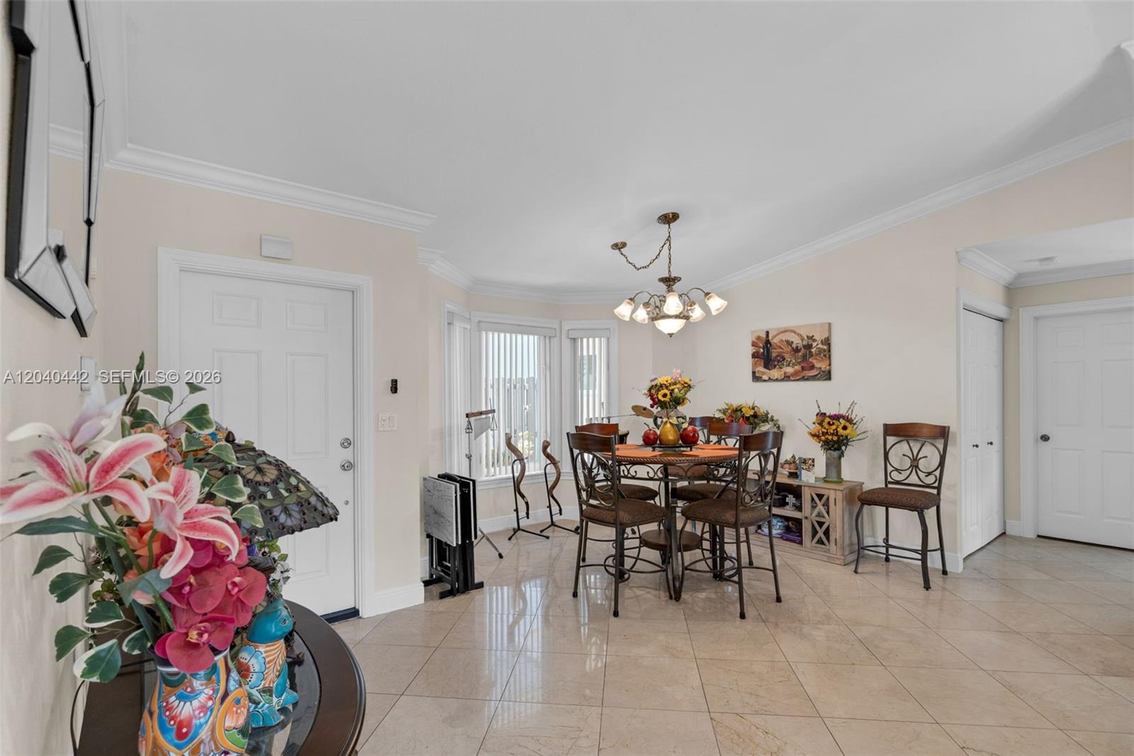 A dining area features a round table with four chairs, tile flooring, and a chandelier — 10170 NW 54th Ter, Doral FL 33178, DORAL, FL