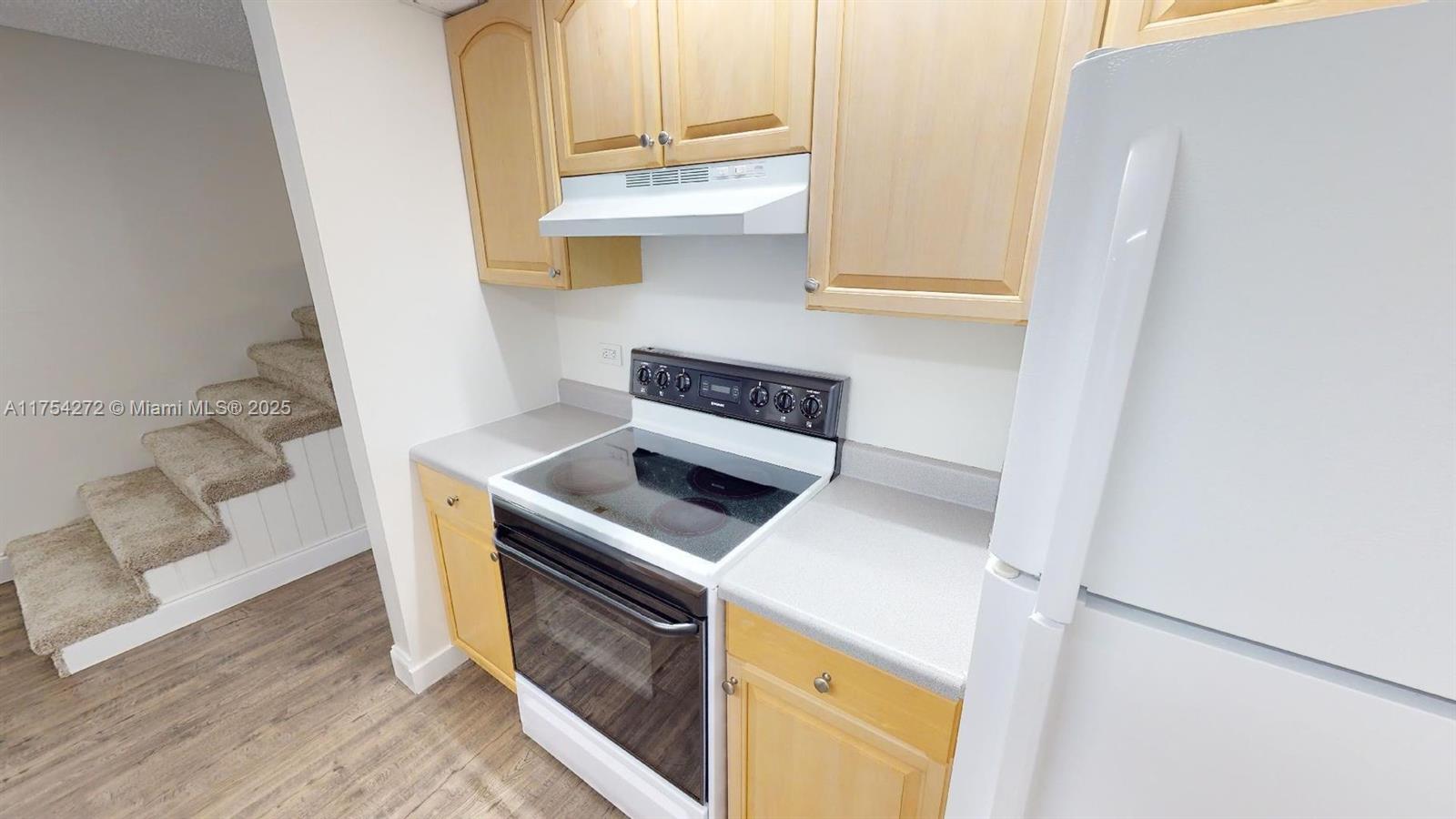 A kitchen features light wood cabinets, a white stove, and a white refrigerator — 300 Ocean Drive # 22, Key Largo FL 33037, KEY LARGO, FL