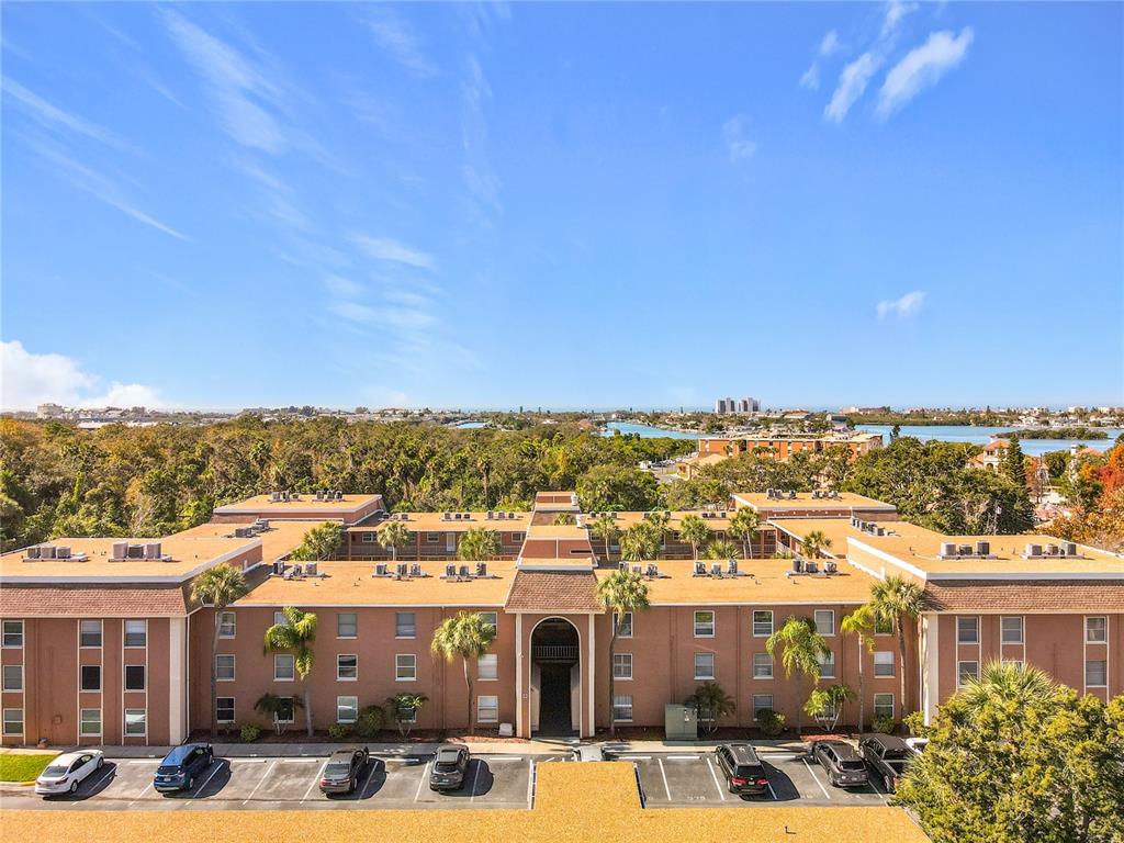 An aerial view shows a multi-story tan apartment building with a parking lot in front — 12760 INDIAN ROCKS ROAD UNIT 583, LARGO, FL