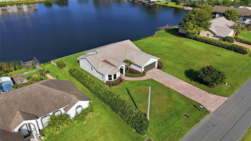 An aerial view of a single-story house with a brick driveway next to a lake — 1422 PATRICIA STREET, KISSIMMEE, FL