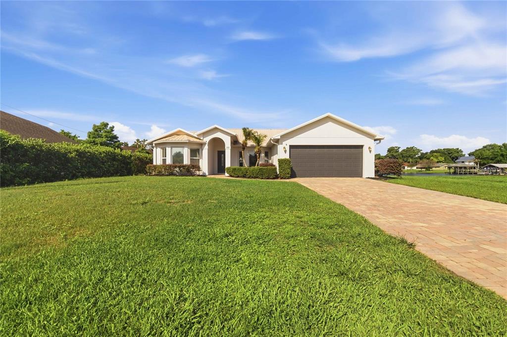 A single-story house with a paved driveway, a two-car garage, and a large front lawn — 1422 PATRICIA STREET, KISSIMMEE, FL