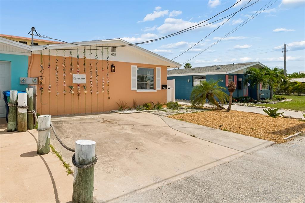 An orange house with a concrete driveway and decorative hanging vines on the front wall — 403 63RD STREET, HOLMES BEACH, FL