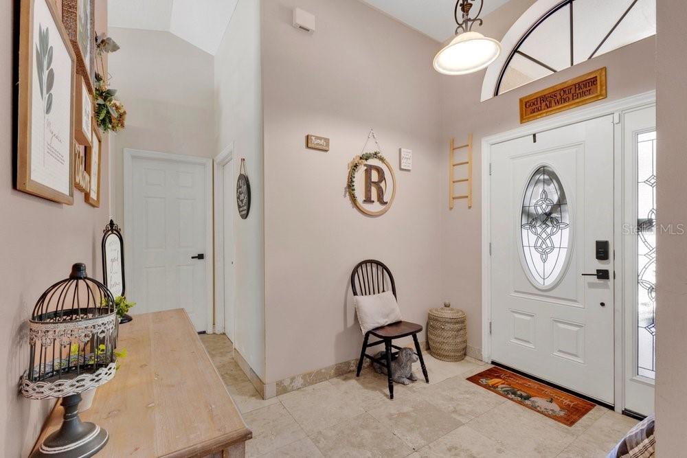 An entryway features tile flooring, a white front door with glass, and a wooden console — 1304 ARIANA WOODS CIRCLE, AUBURNDALE, FL
