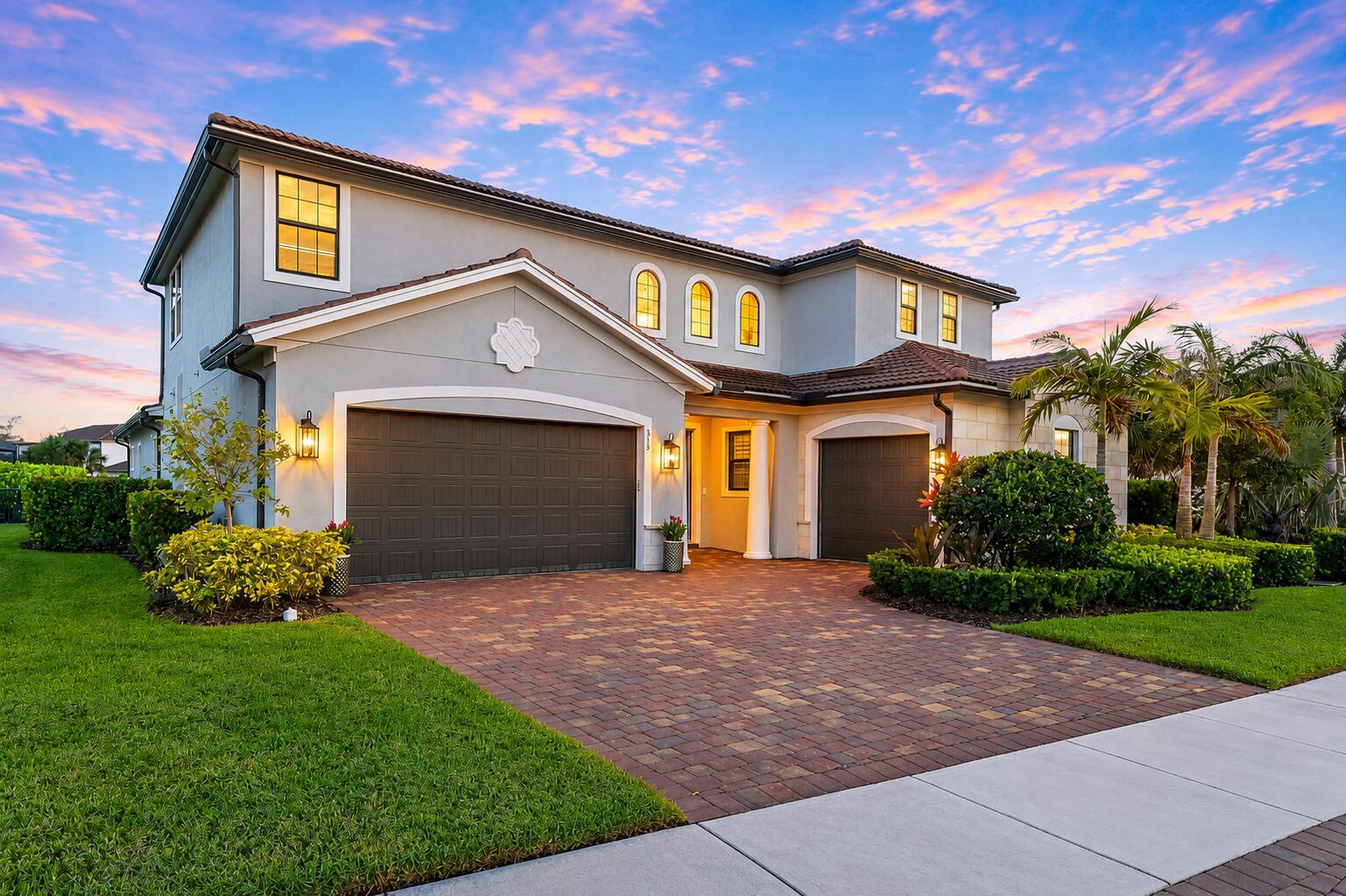 A two-story house with a gray stucco exterior, two garages, and a brick paver driveway — 315 Sonoma Isles Circle, Jupiter FL 33478, JUPITER, FL