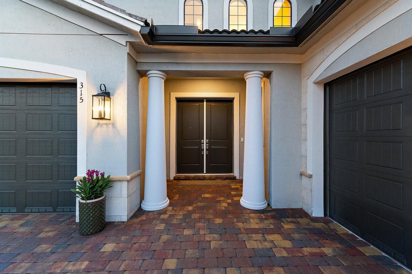 A front entryway features a paved courtyard, two white columns, and dark double doors — 315 Sonoma Isles Circle, Jupiter FL 33478, JUPITER, FL
