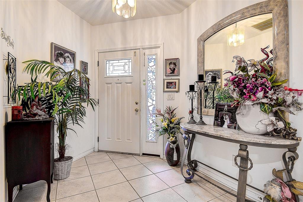 An entryway features tile flooring, a white front door with sidelights, and a console table — 14985 ALAN COURT, LARGO, FL