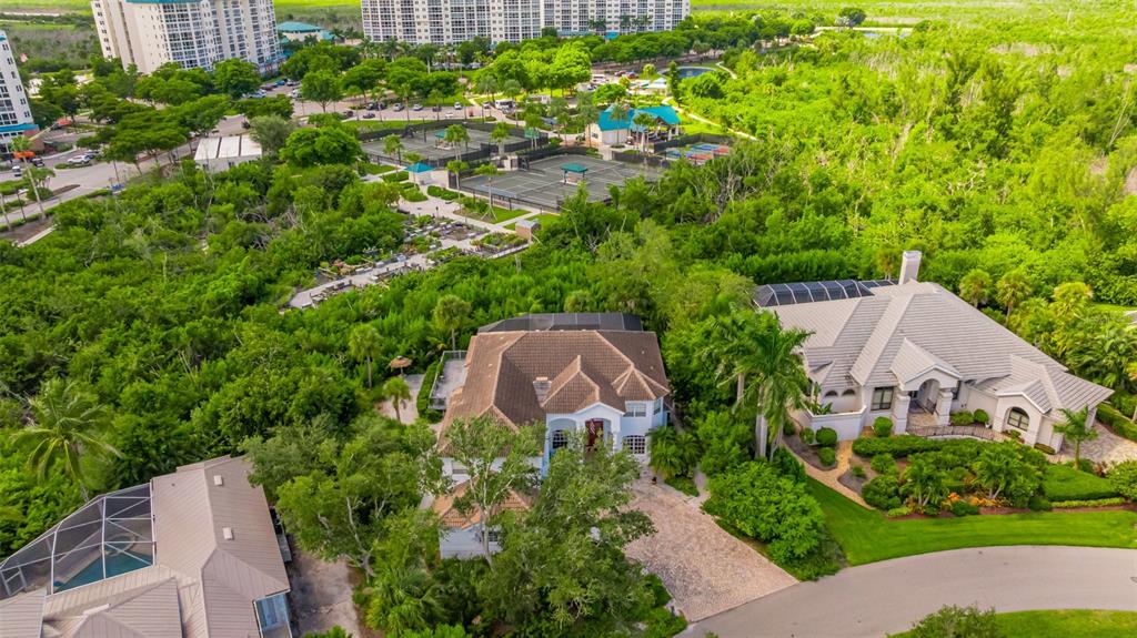 An aerial view shows two large houses surrounded by dense trees near tennis courts — 13881 BLENHEIM TRAIL ROAD, FORT MYERS, FL