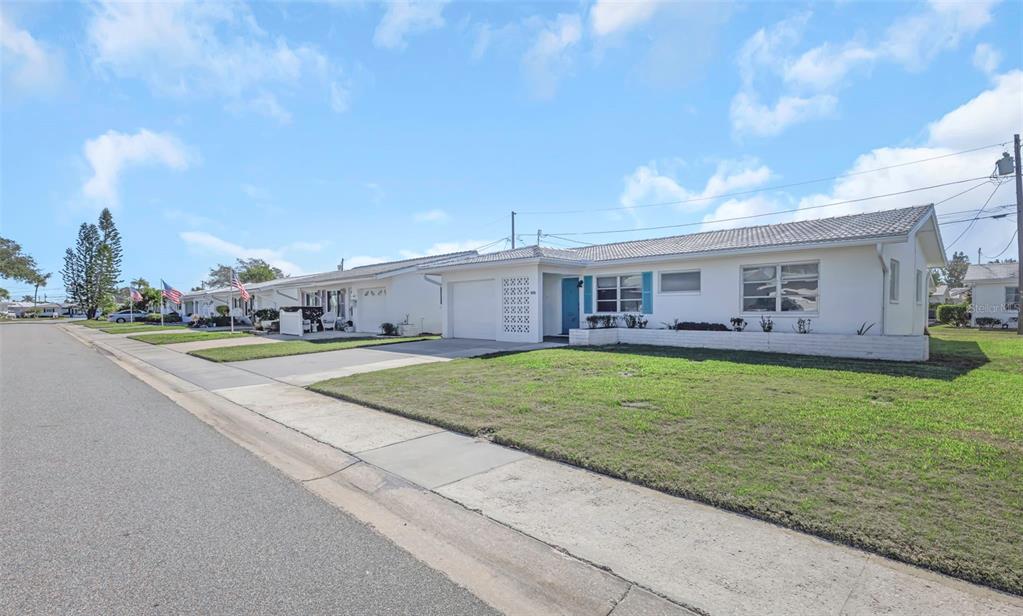 A white single-story house with a garage and a lawn sits along a residential street — 4488 100TH AVENUE N, PINELLAS PARK, FL