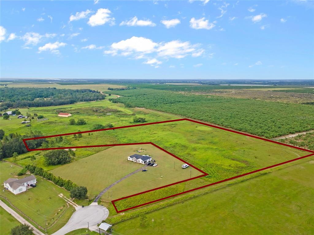 An aerial view shows a house situated on a large, grassy lot outlined in red — BROOKE LAKES DRIVE, FORT MEADE, FL