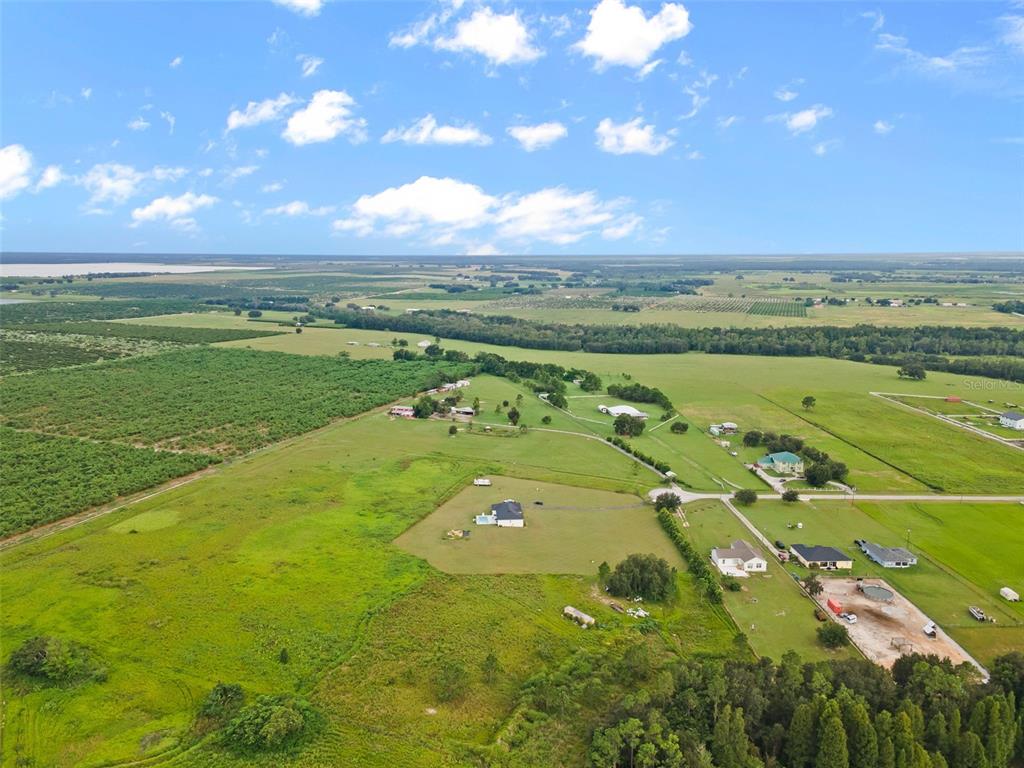 An aerial view shows a rural landscape with scattered houses, pastures, and a large field — BROOKE LAKES DRIVE, FORT MEADE, FL