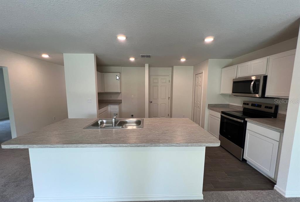 A bedroom with light-colored walls, gray carpet, a single window, and a ceiling light — 70 RYMSHAW DRIVE, PALM COAST, FL