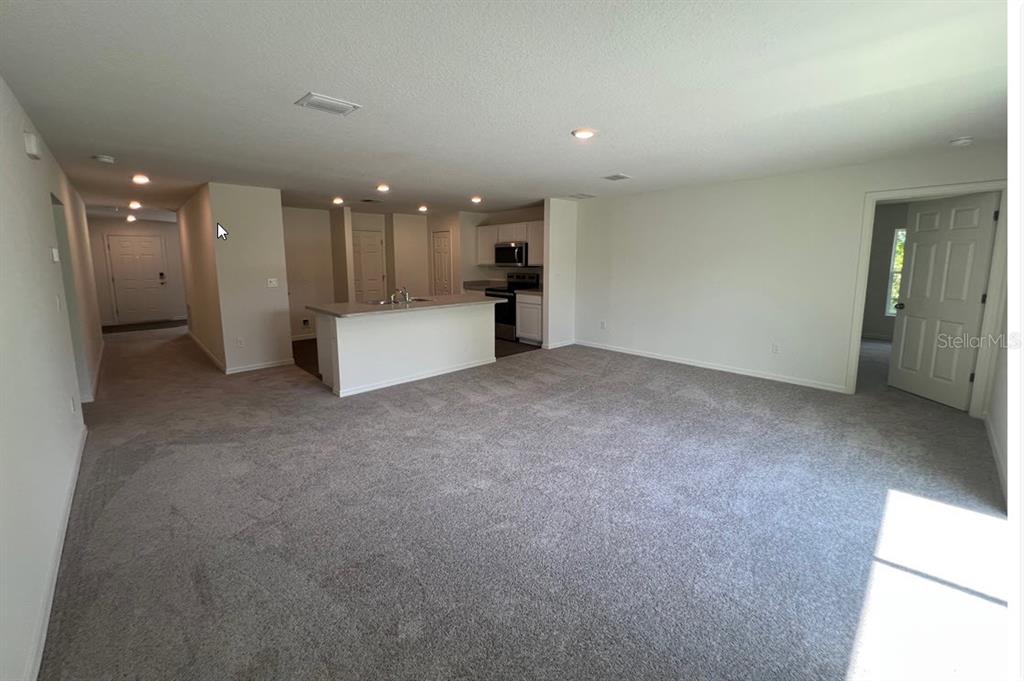 An empty bedroom with light-colored walls, gray carpet, a single window, and a ceiling light — 70 RYMSHAW DRIVE, PALM COAST, FL