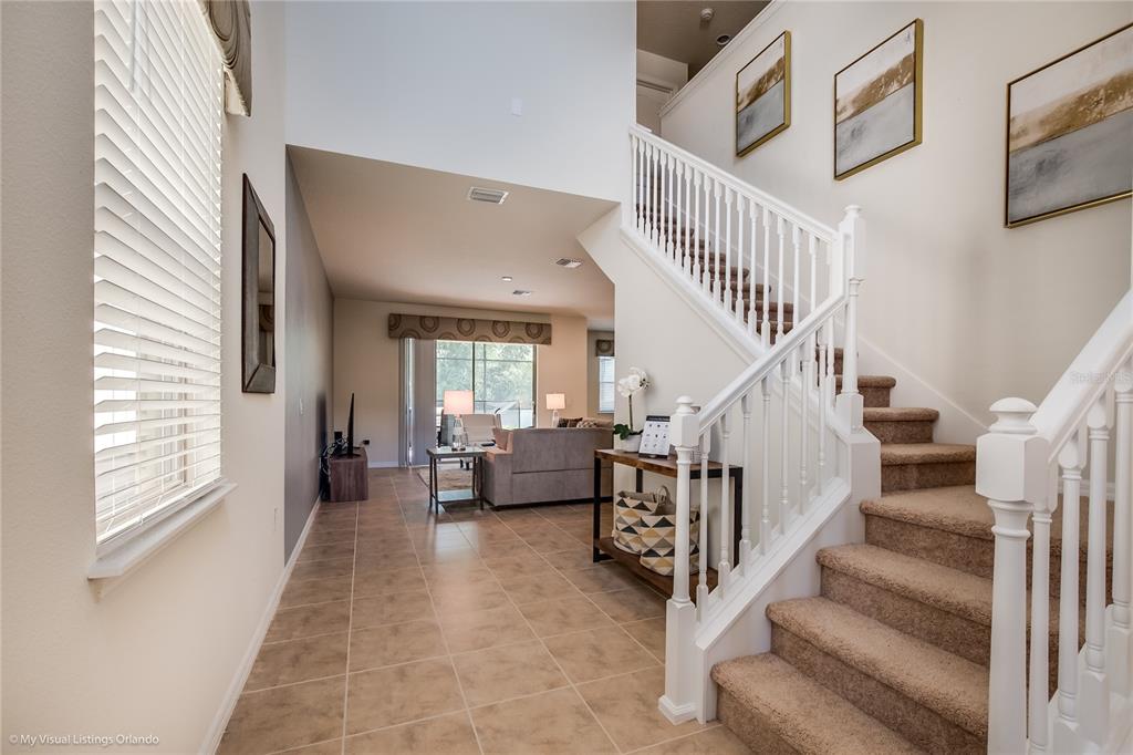 A tiled entryway leads to a living area with stairs on the right — 1857 NICE COURT, KISSIMMEE, FL